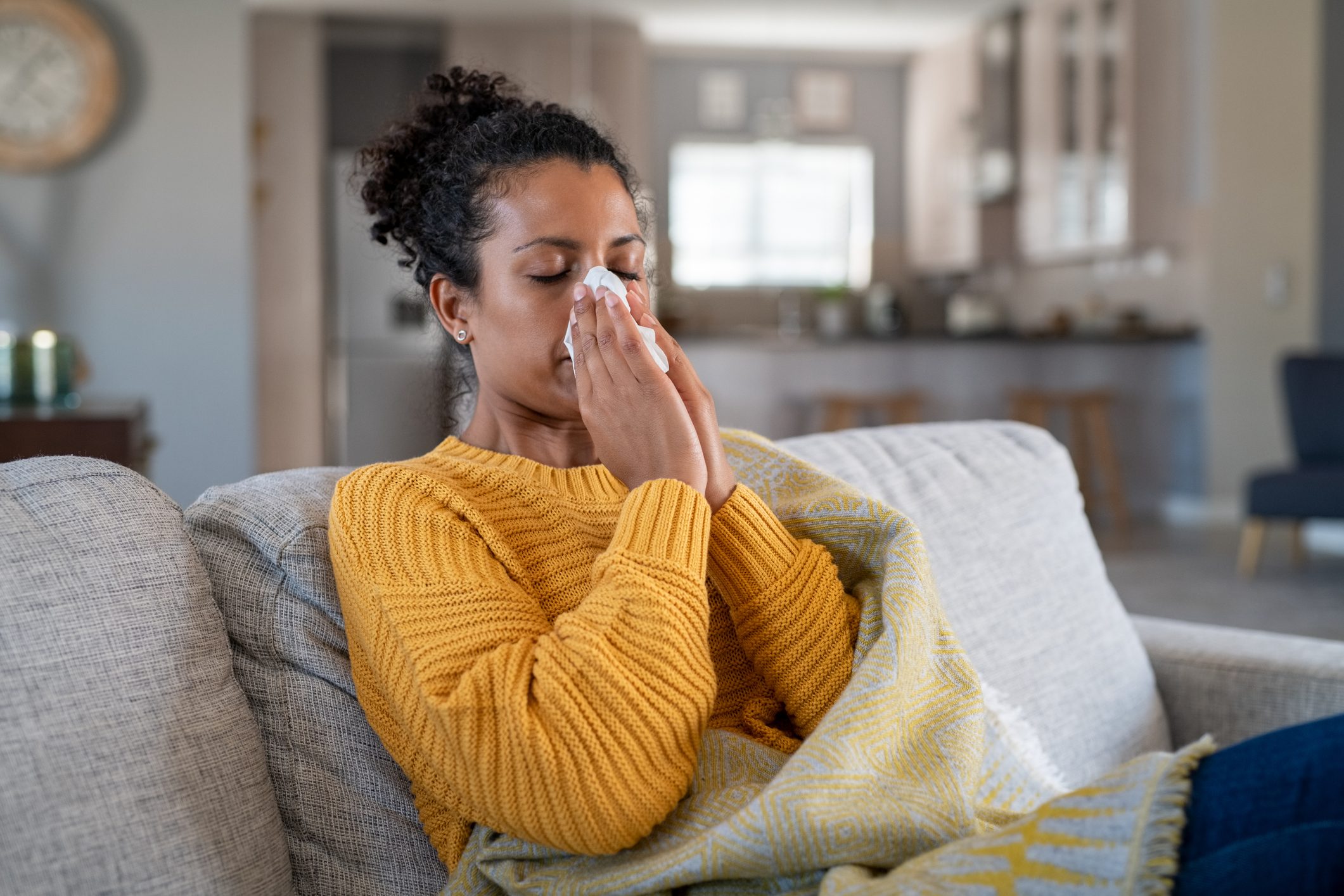 Cold sick african woman blowing nose