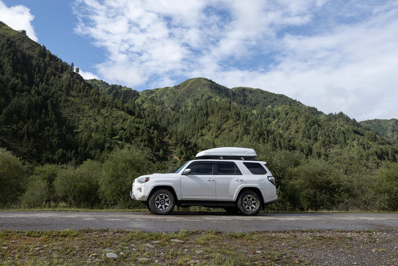 Driving off road car in high altitude forest mountains