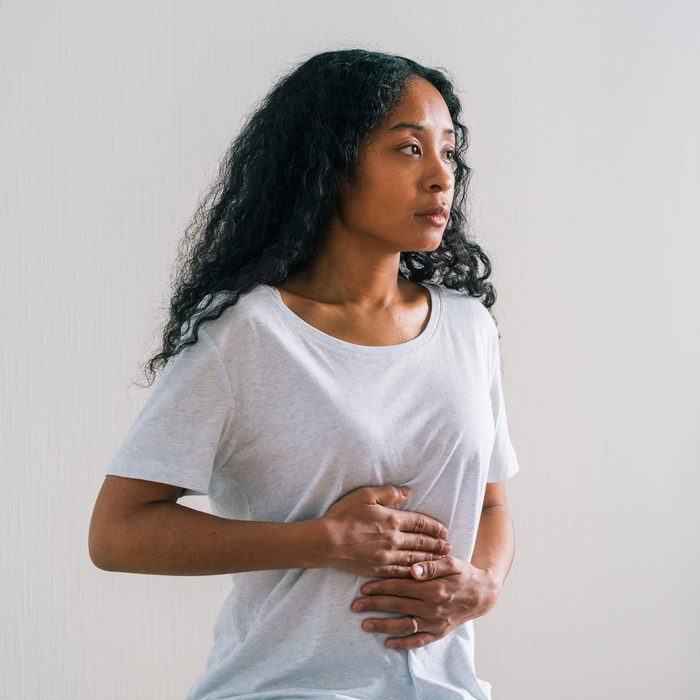 Young African-american patient complaining about belly ache to mature female doctor