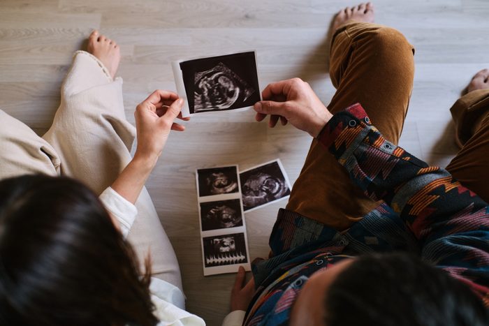 Couple sitting on the ground watching ultrasound.