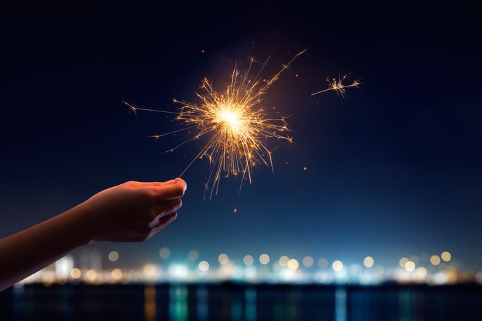 Female hand holding a burning sparkler