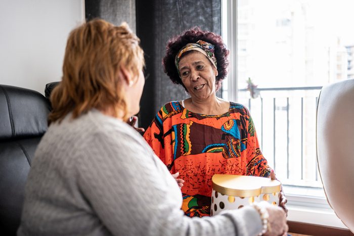 Senior woman thanking the her friend in the living room at home