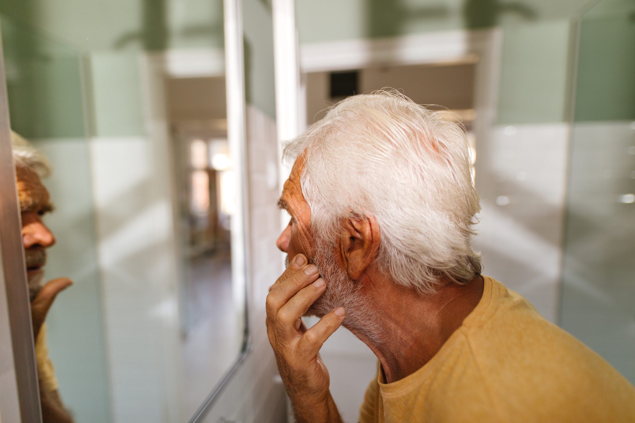 Senior man doing his morning routine in bathroom