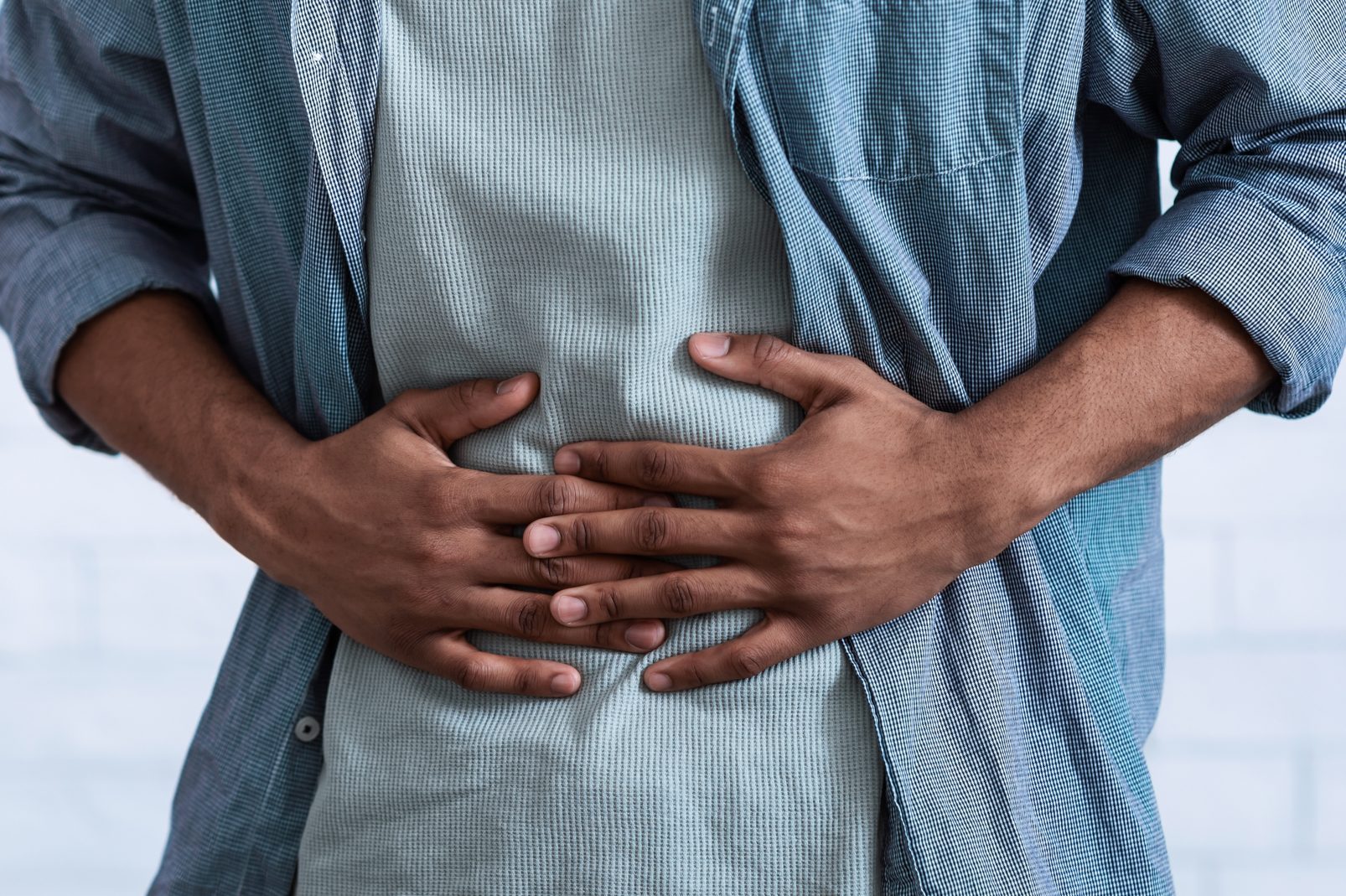 Black Guy Touching Aching Abdomen Having Stomachache, Gray Background, Cropped