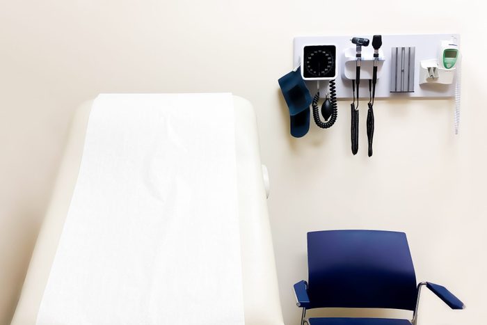 access to medical care: wall-mounted medical diagnostic equipment beside standard patient examination chair