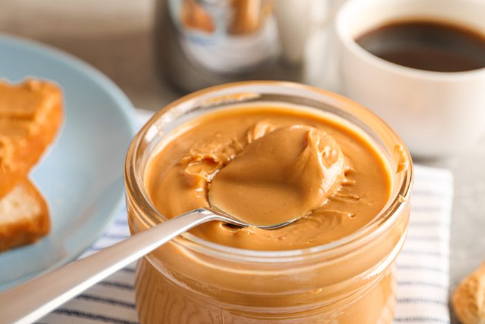 Yummy peanut butter breakfast on grey background, space for text and closeup