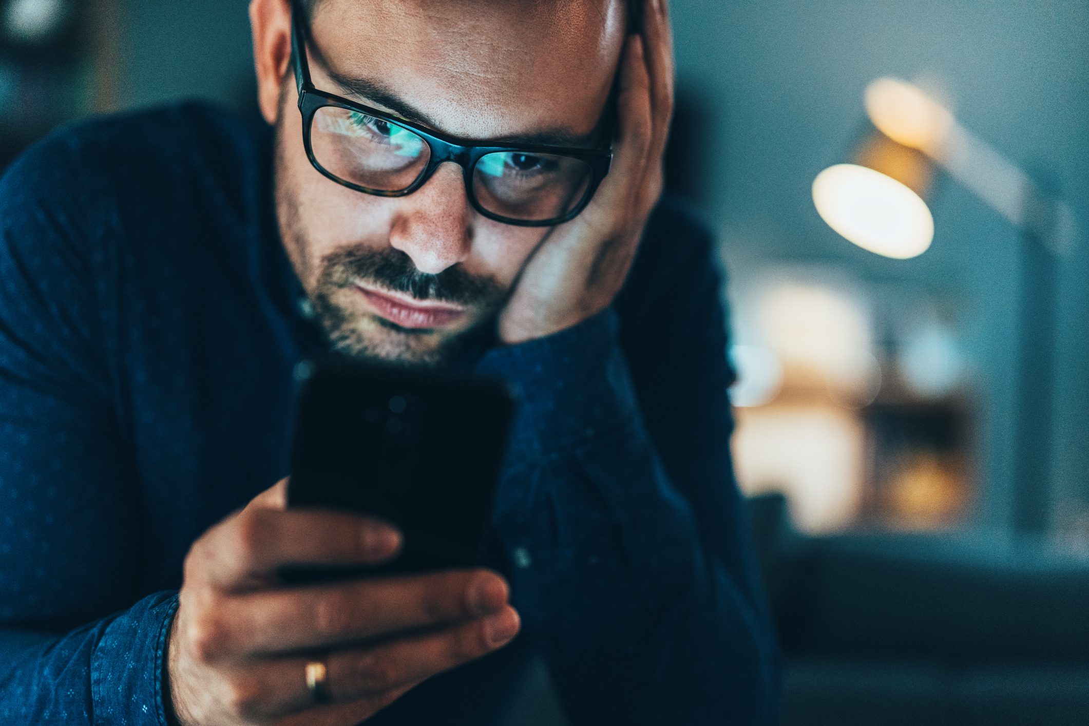 Young man addicted to social media texting in the dusk at home