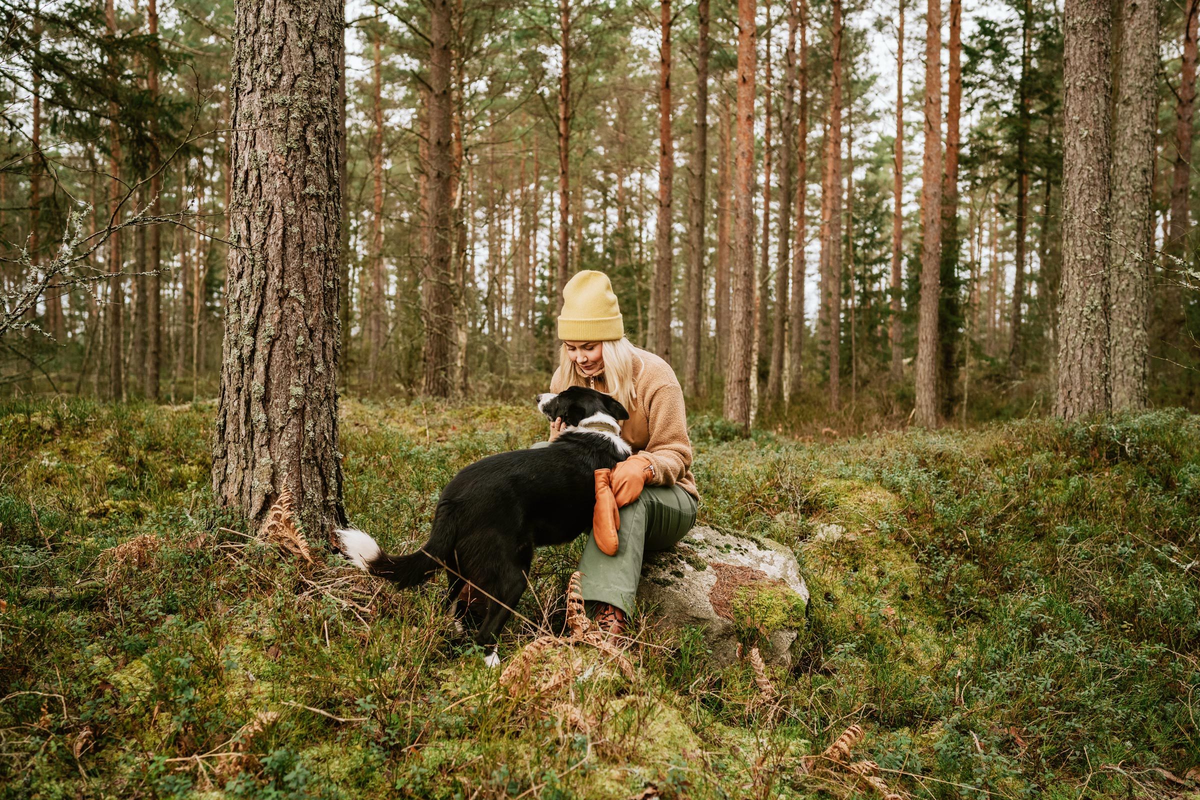 woman and her border collie spending time in the forest to avoid feeling burned out