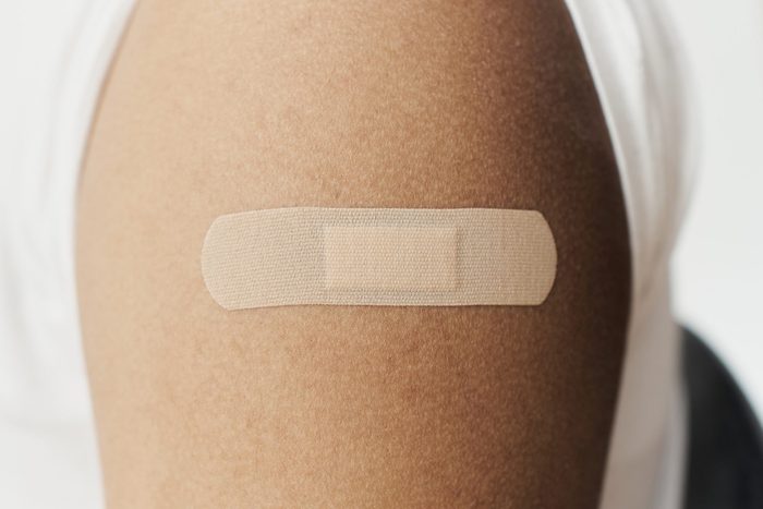 adhesive bandage, on the arm of a black man after giving him the covid19 vaccine.