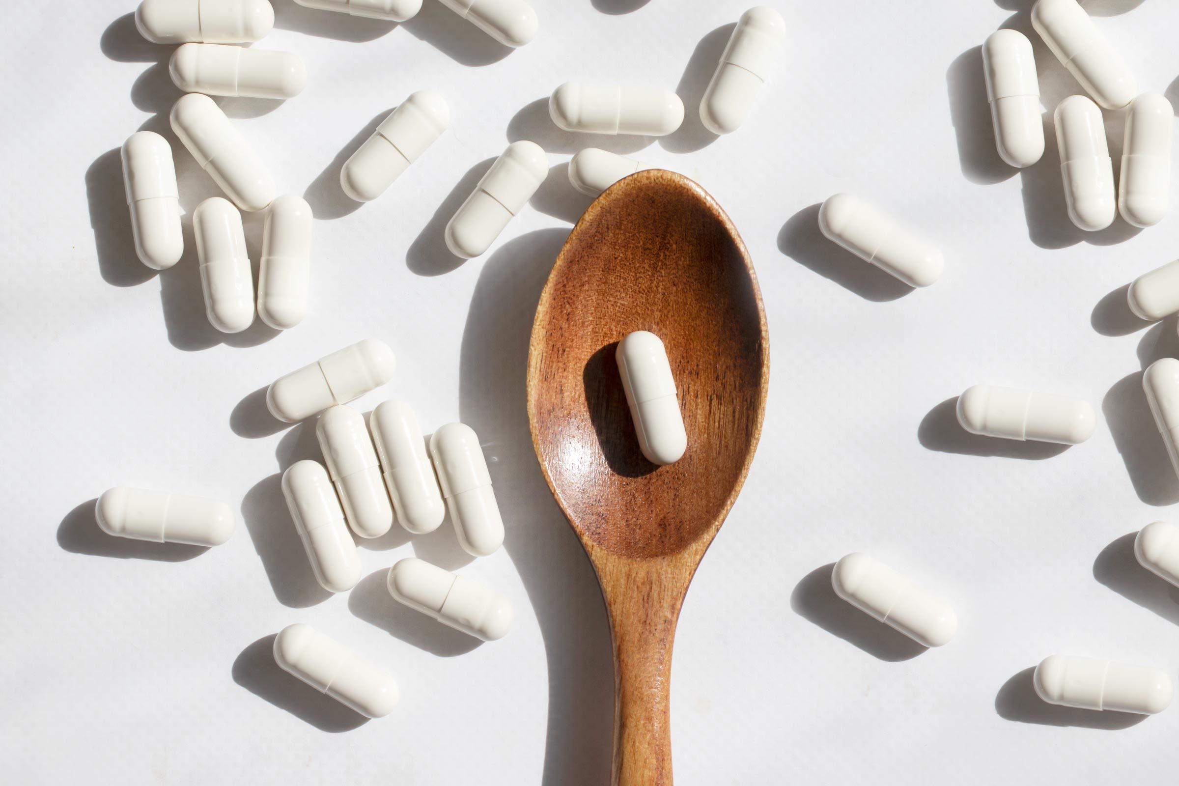 white zinc supplements on a wooden spoon