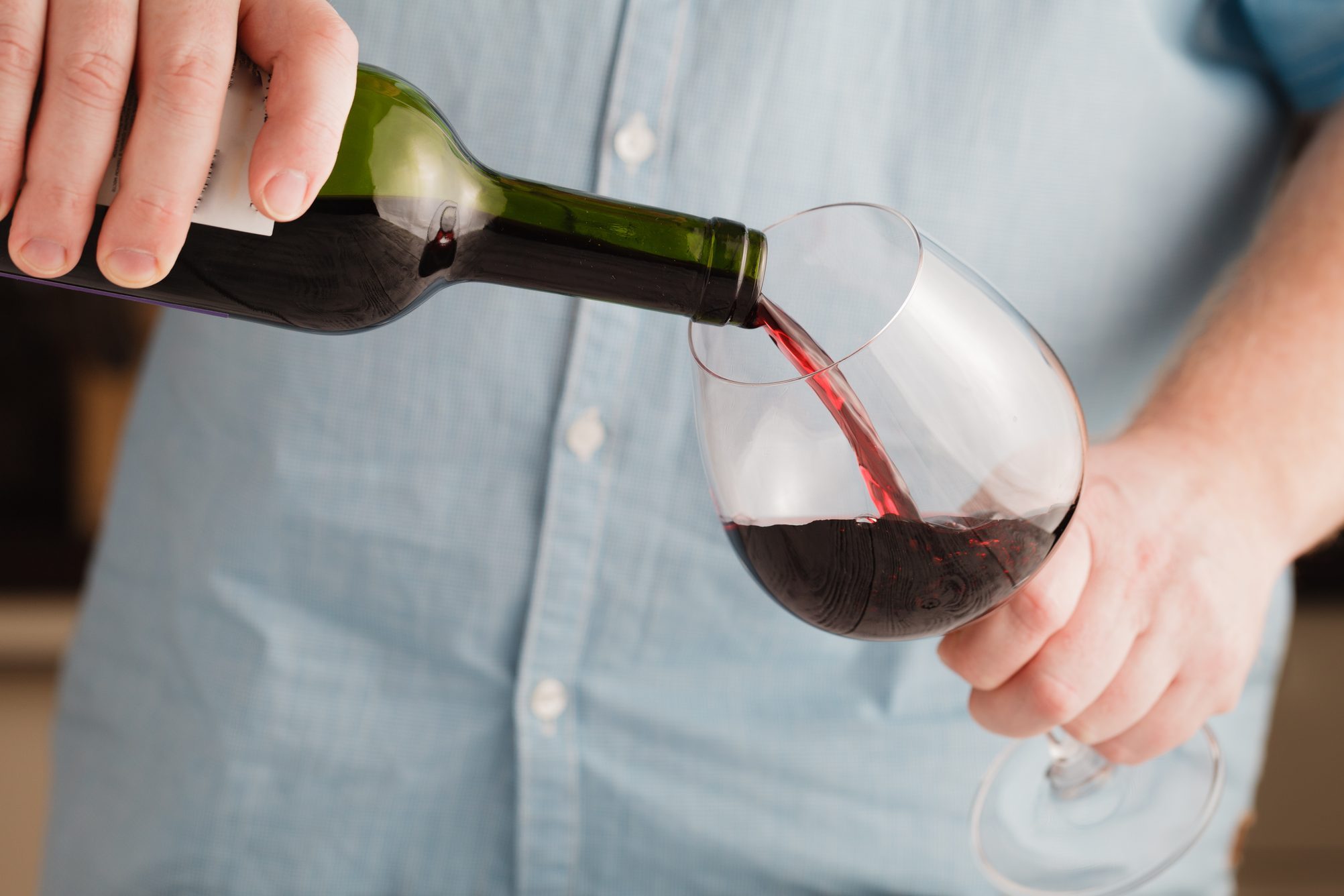 Red wine pouring into a wine glass. Shallow depth of field