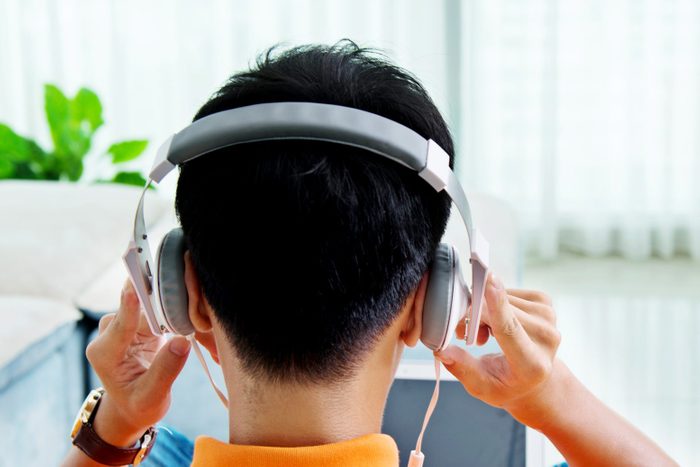 Rear view of asian man with laptop and headphone