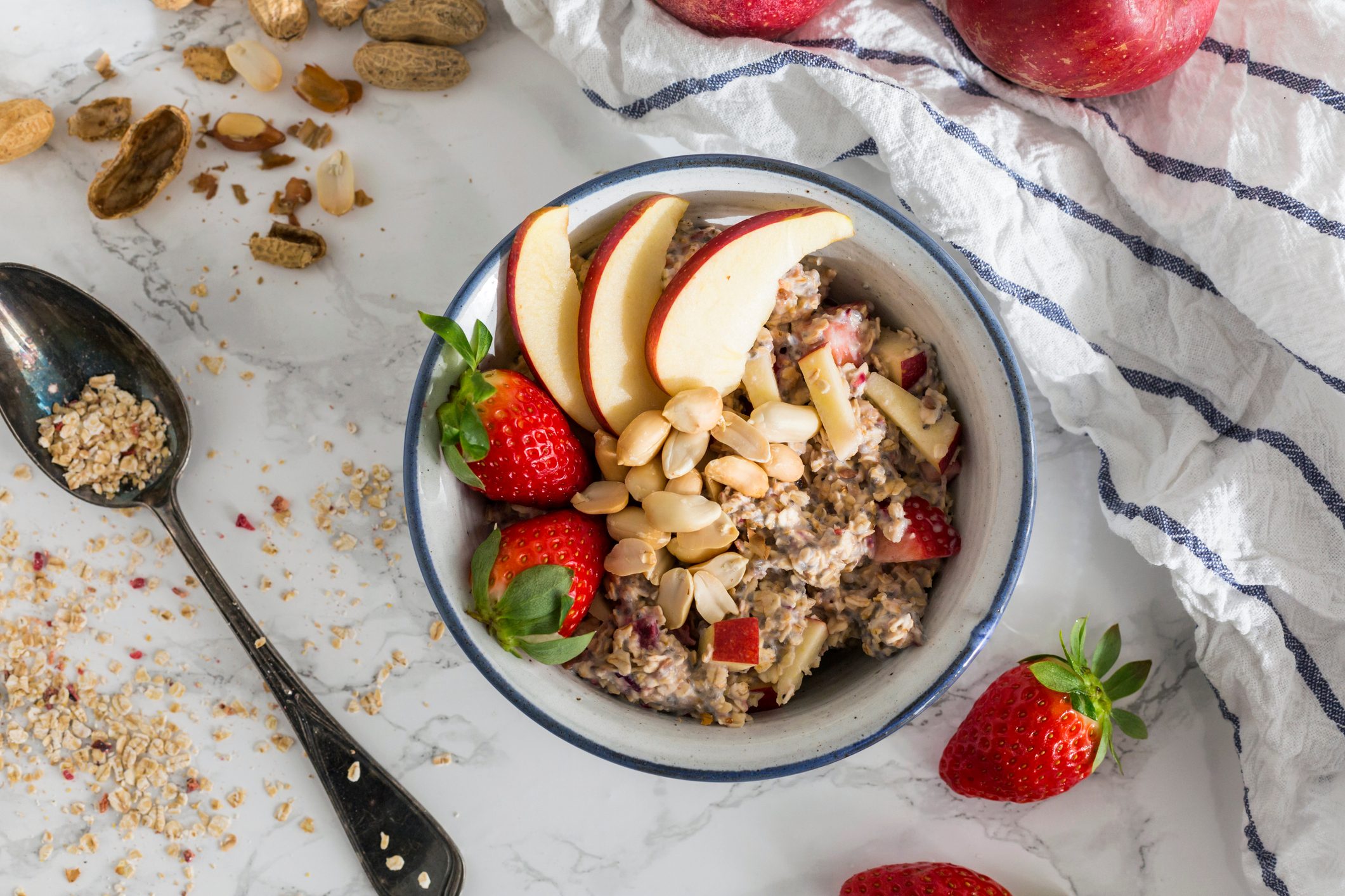 Bowl of oats porridge topped with fruit and nuts