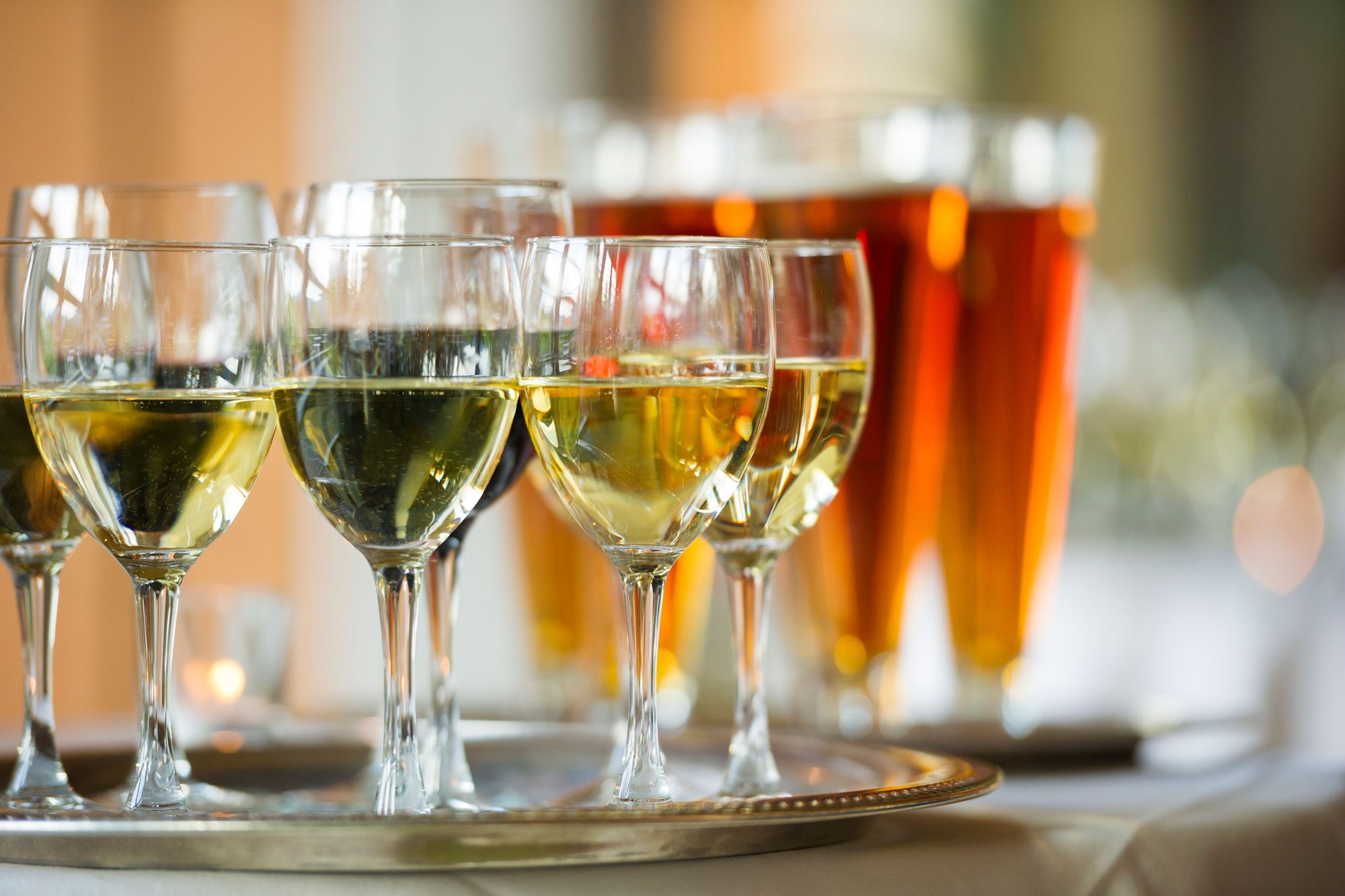 Several Glasses Of Wine And Beer On A Serving Tray with beer in the background