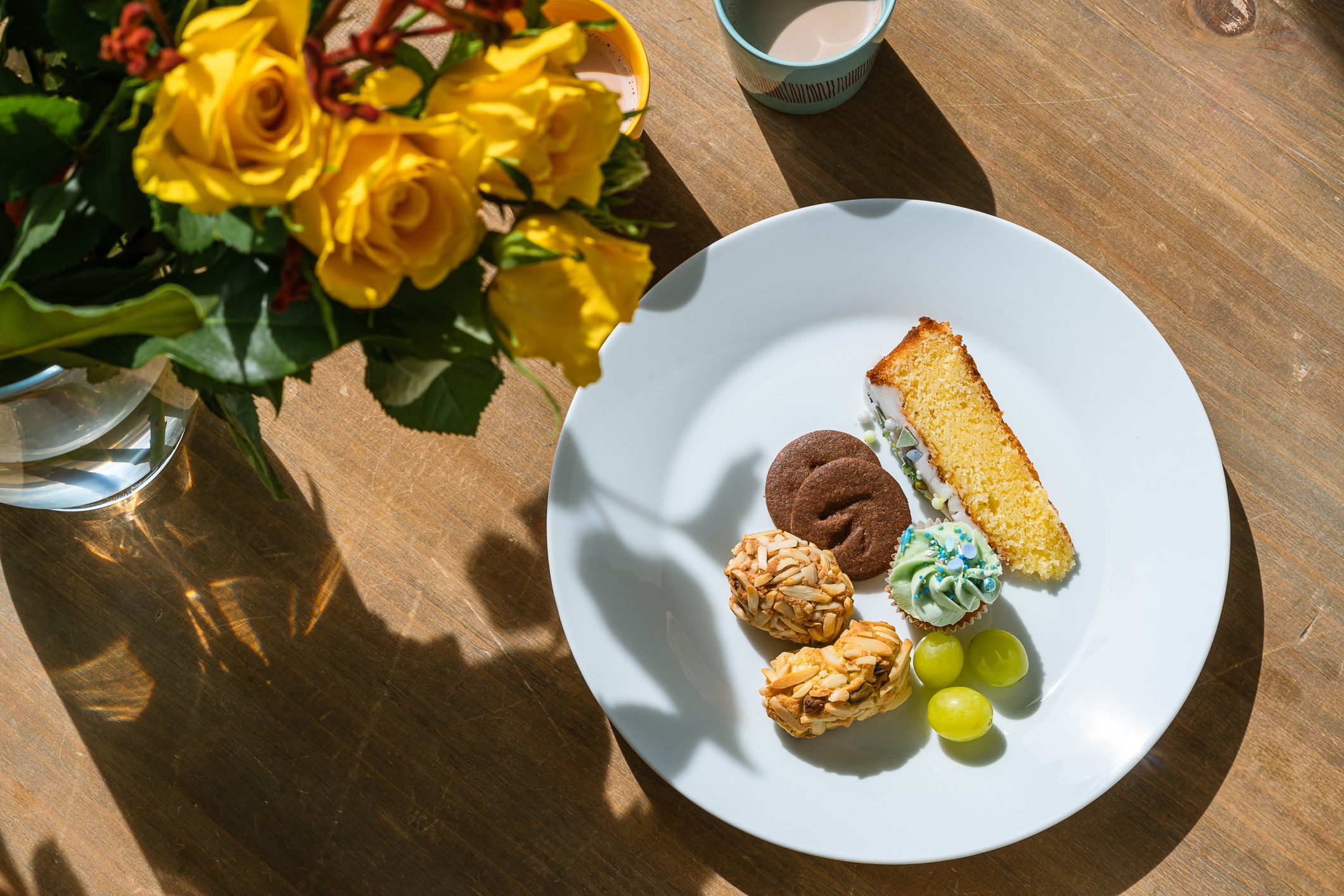 Sweet pastries on plate, hot chocolate on wooden table at home