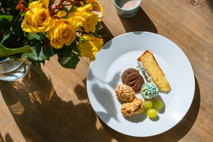 Sweet pastries on plate, hot chocolate on wooden table at home