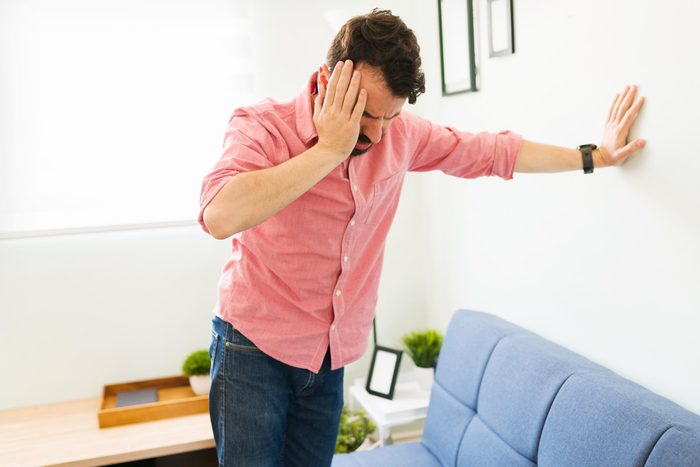 man leaning on the wall and feeling dizzy after mini stroke
