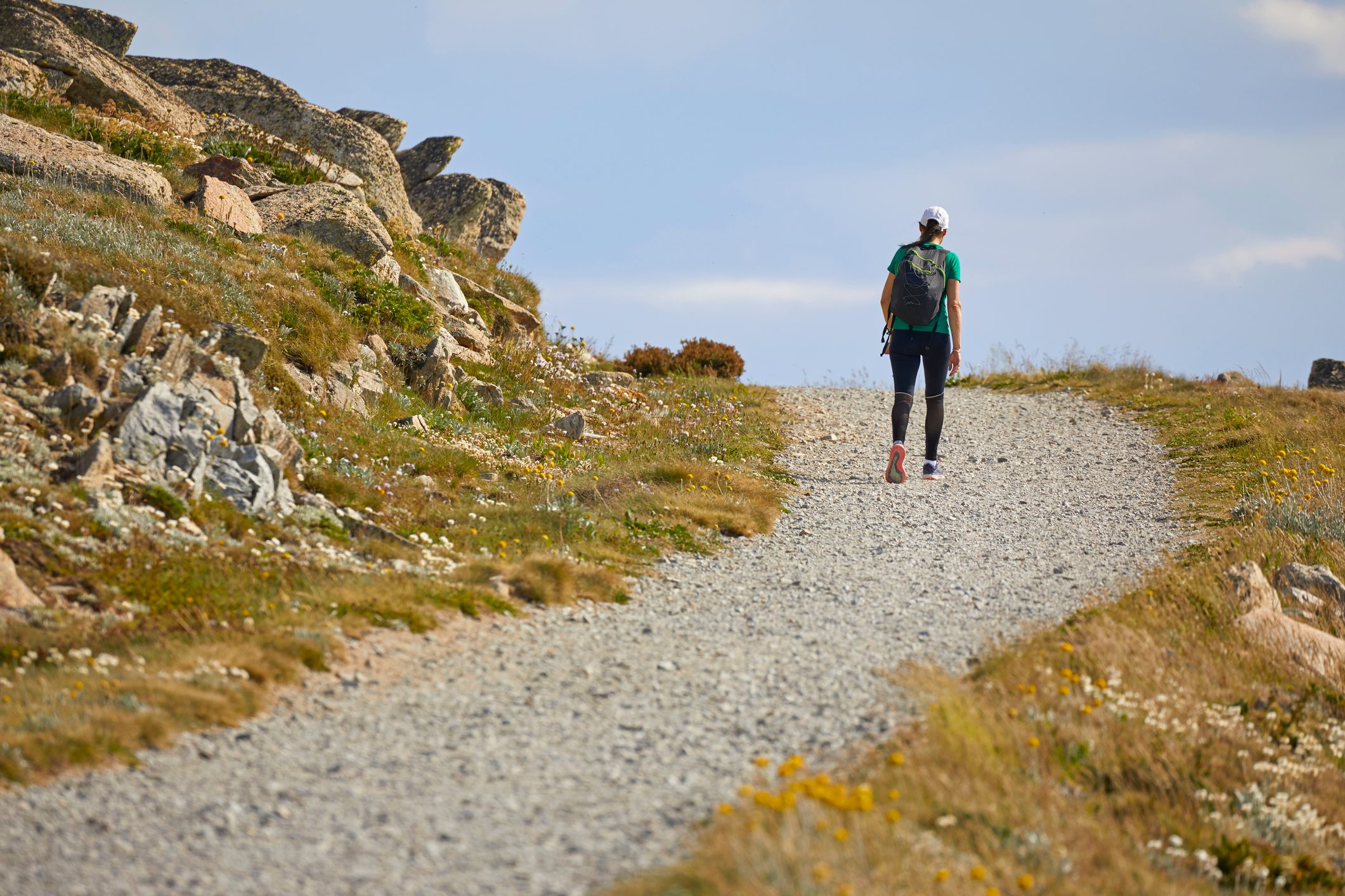 Woman hiking, running, walking on footpath, track on mountain, Kosciuszko National Park, Australia