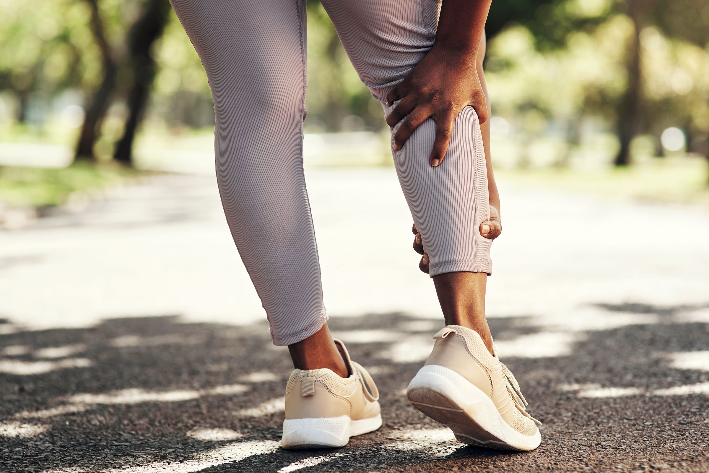 walking woman holding her calves