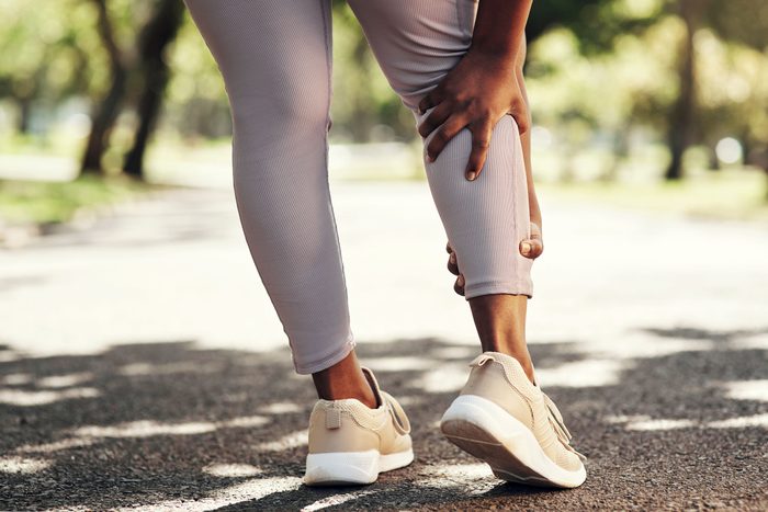 walking woman holding her calves