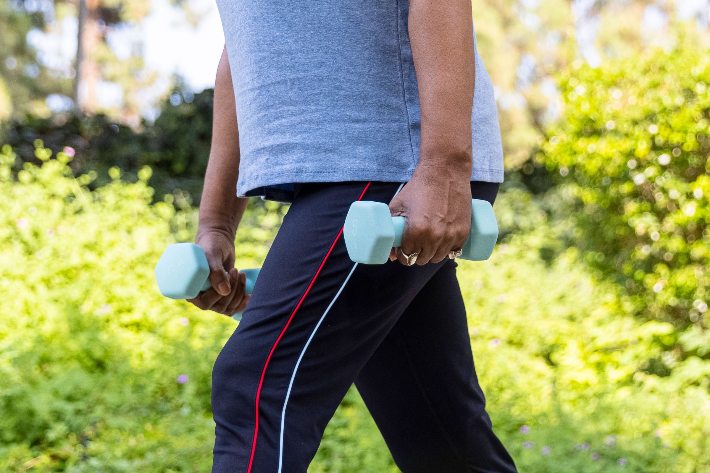 hands holding weights in each hand while walking