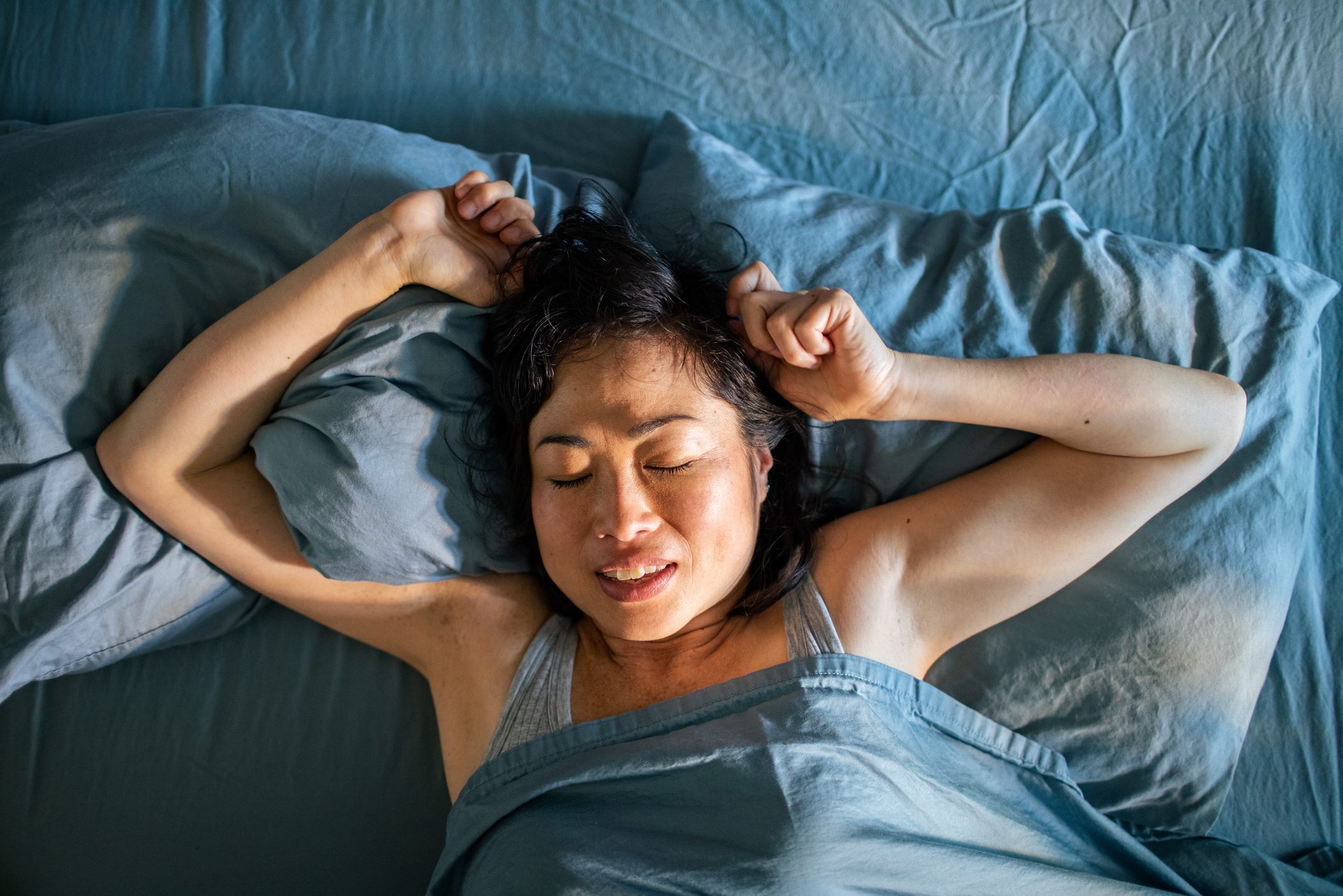 Young Japanese woman sleeping in a bed in a bedroom