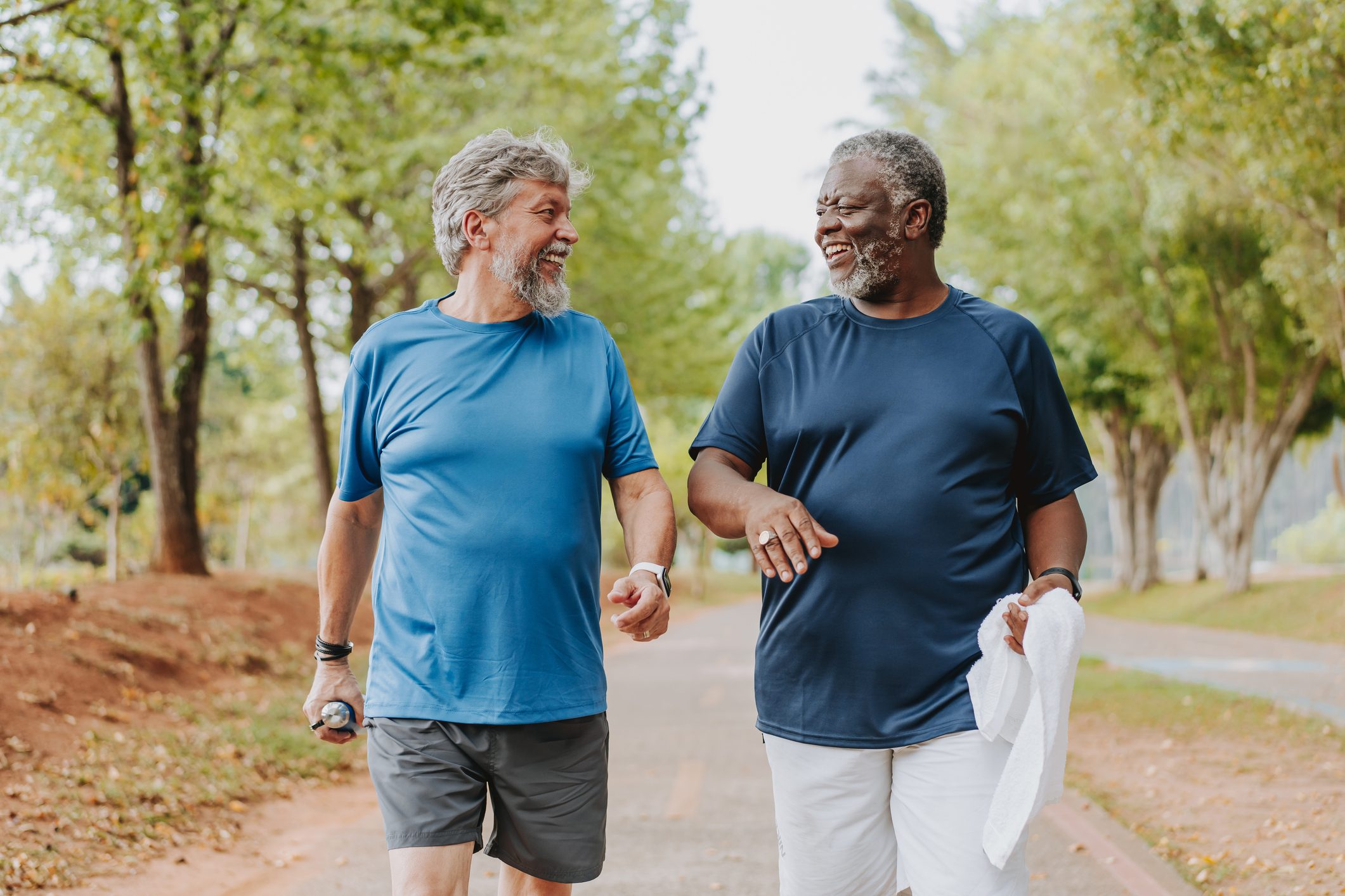 Two elderly friends walking together in public park