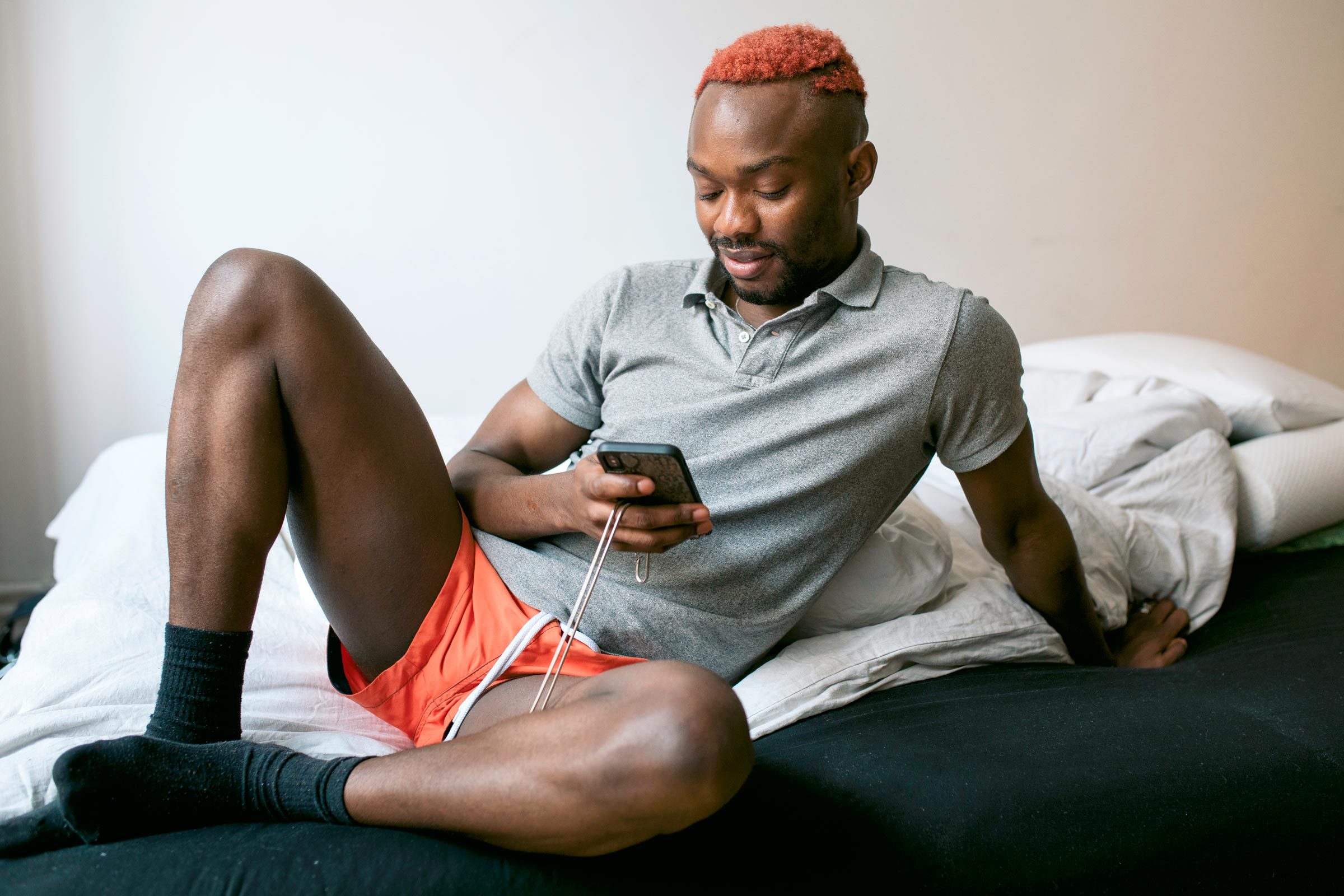 man in bed looking at his phone