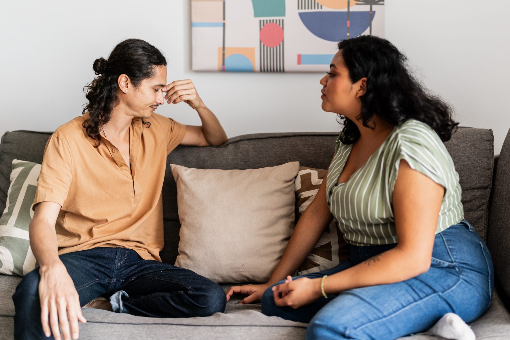 Young couple arguing in living room at home