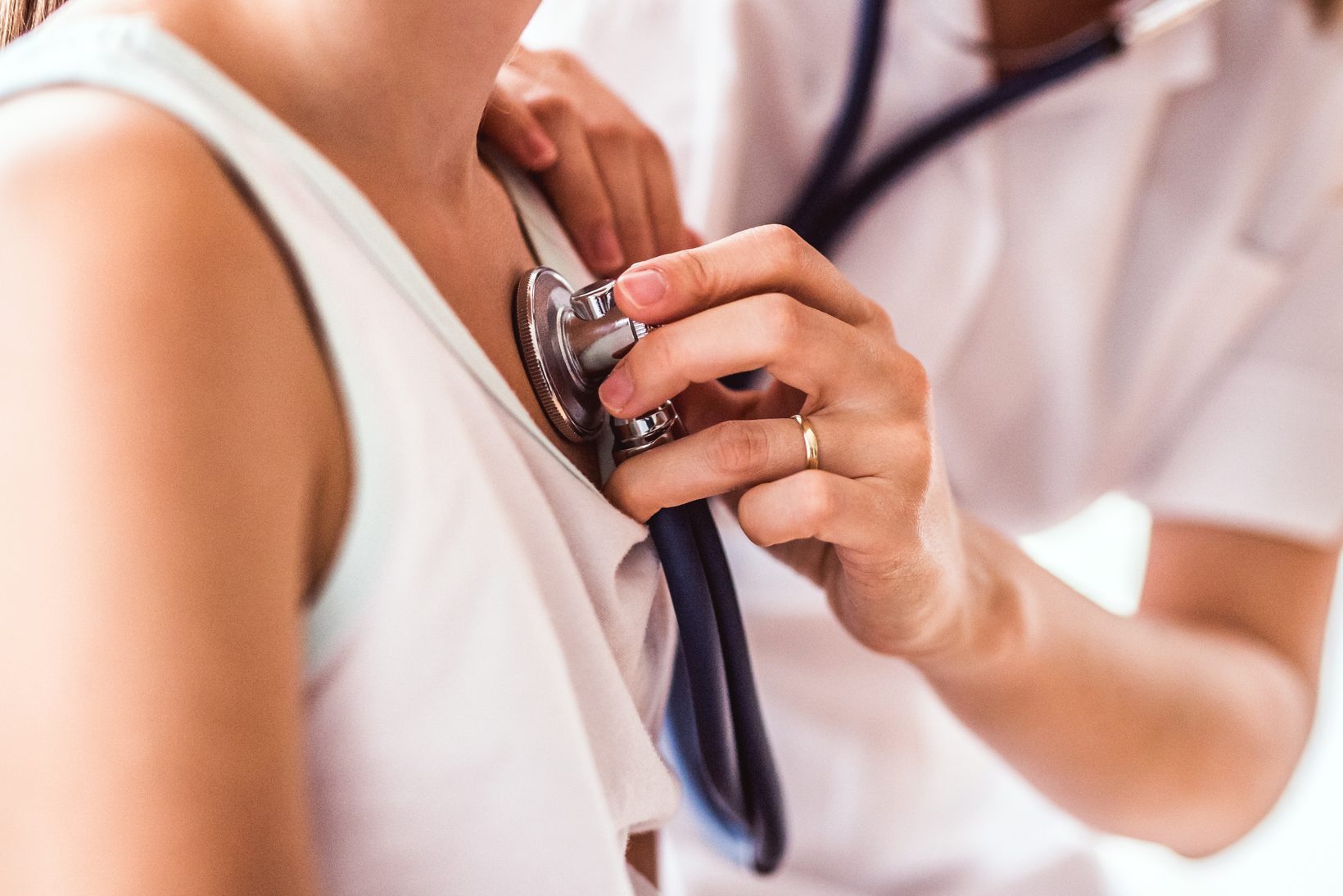 Young female doctor examining a small girl in her office.