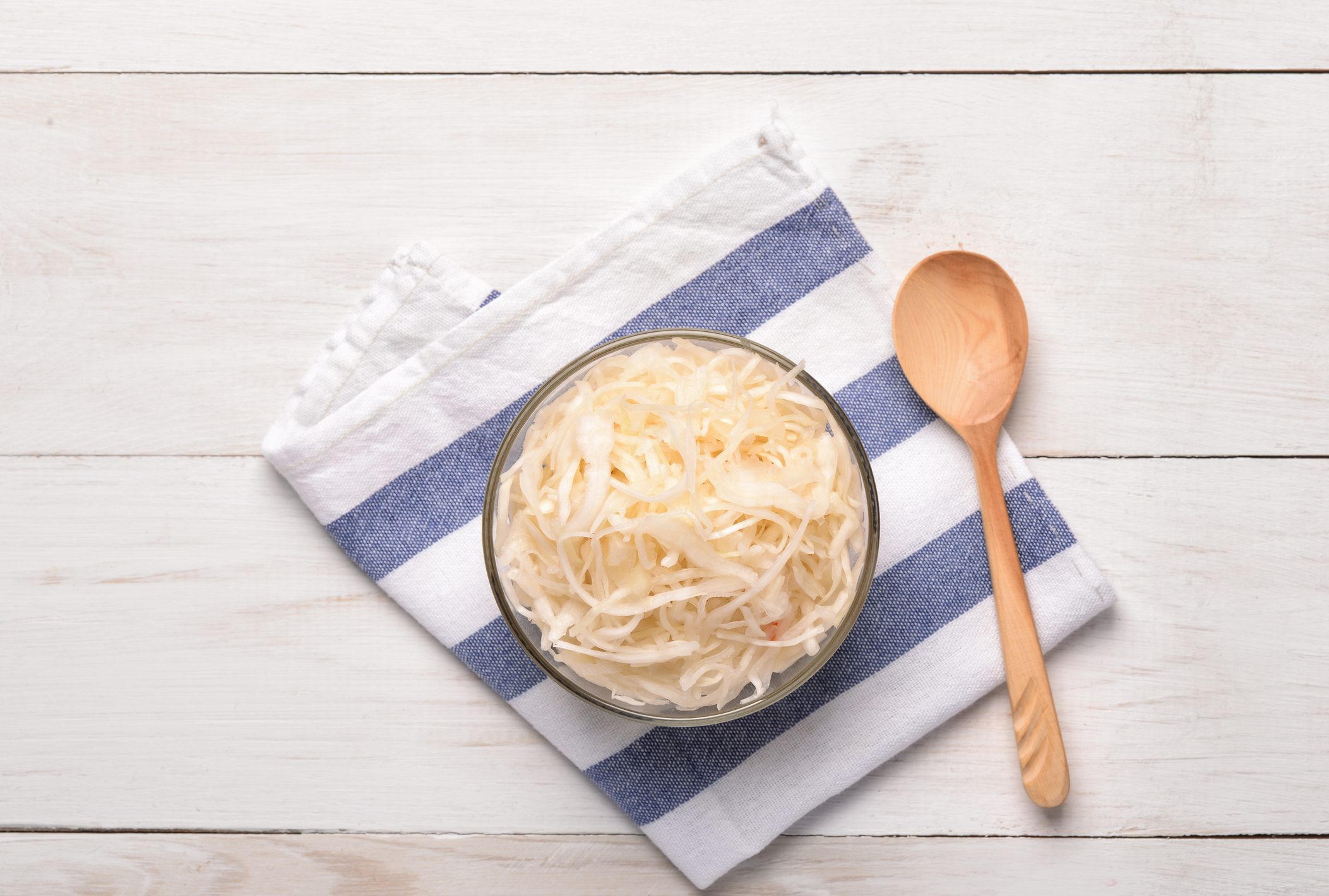 Top view of sauerkraut in glass bowl on wooden table