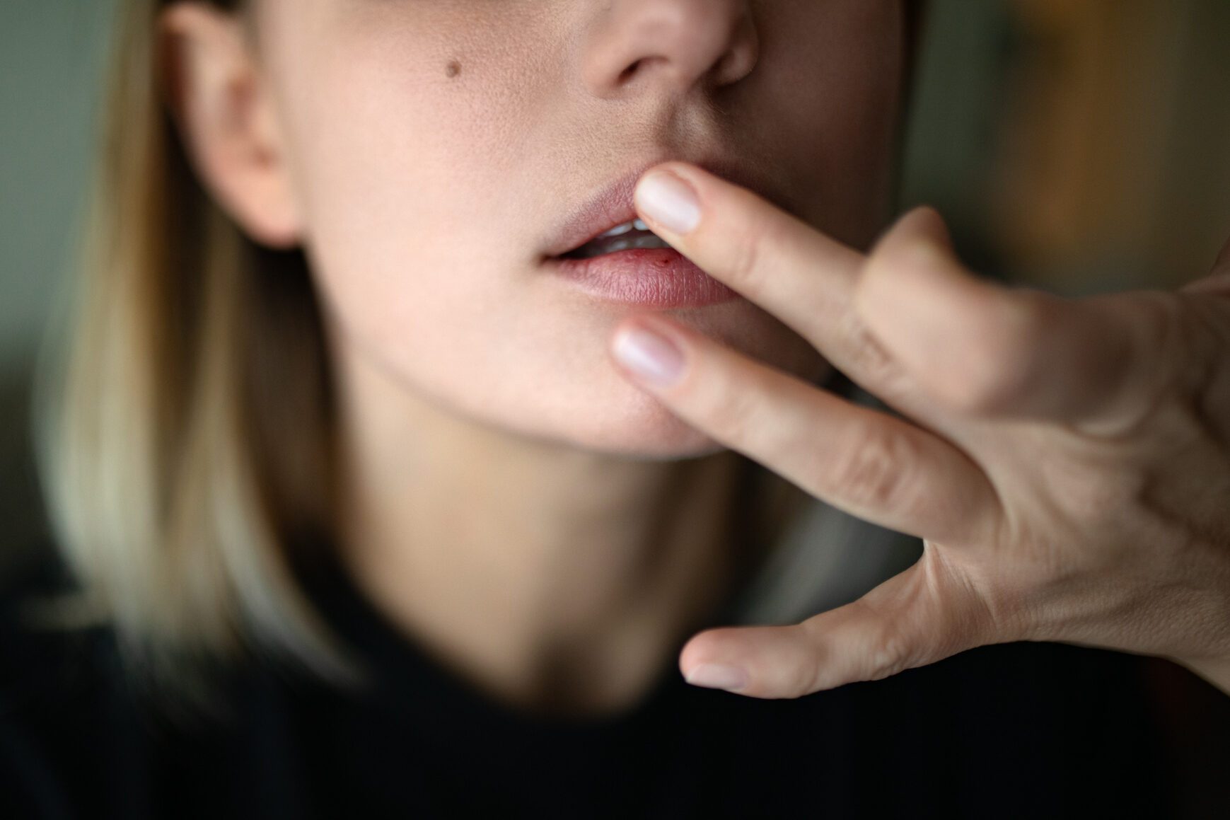 Close-up of beautiful woman touching her lips.