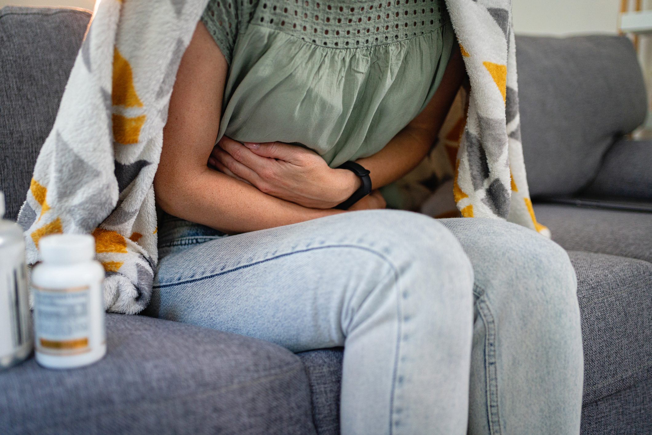 Unrecognizable Caucasian woman in pain, holding on her stomach