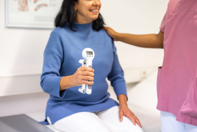 Mature Woman Using A Hand Dynamometer To Test Her Maximum Handgrip Strength
