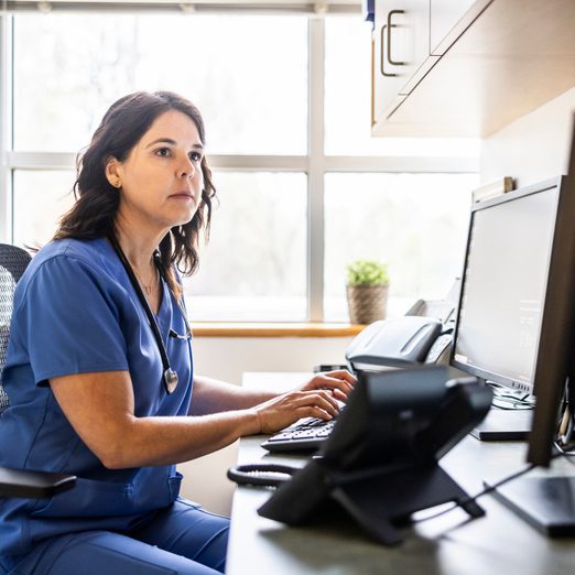 Nurse Working At Computer In Exam Room