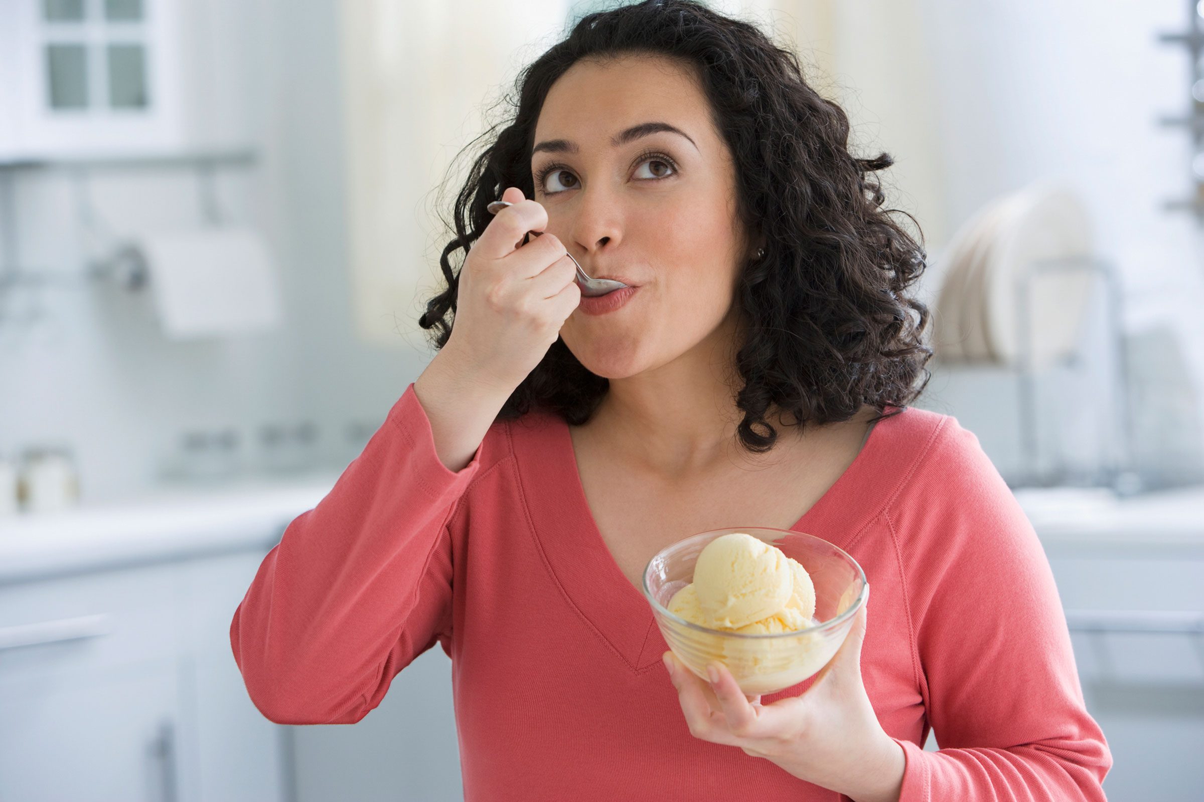 A woman eating ice cream from a bowl