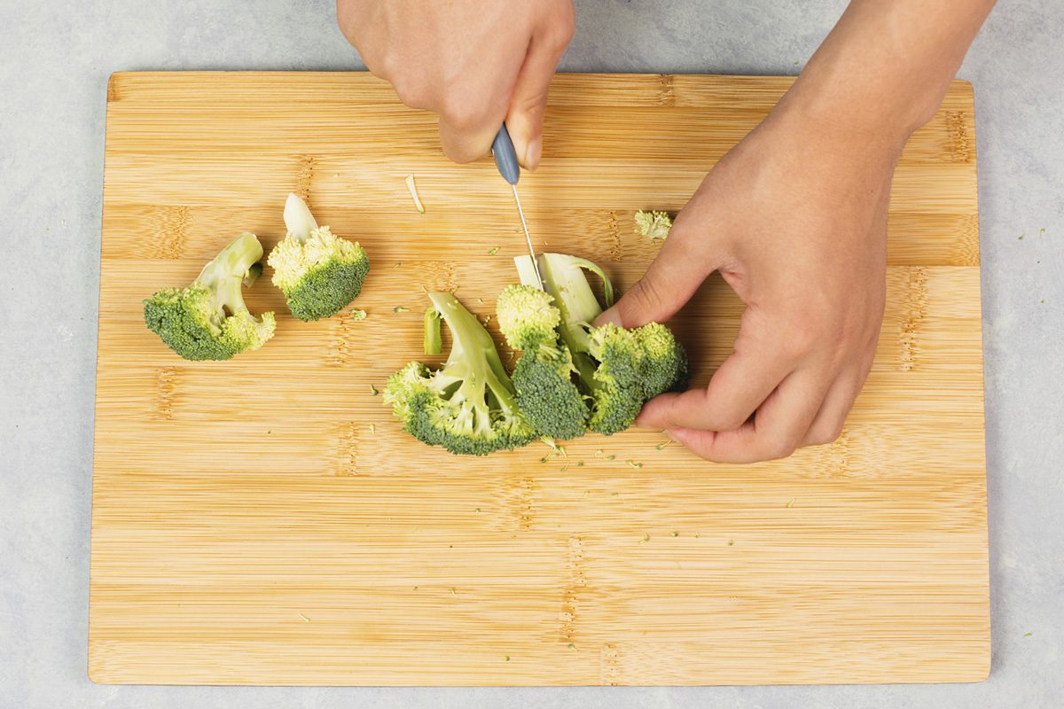 Cutting broccoli on a wooden board