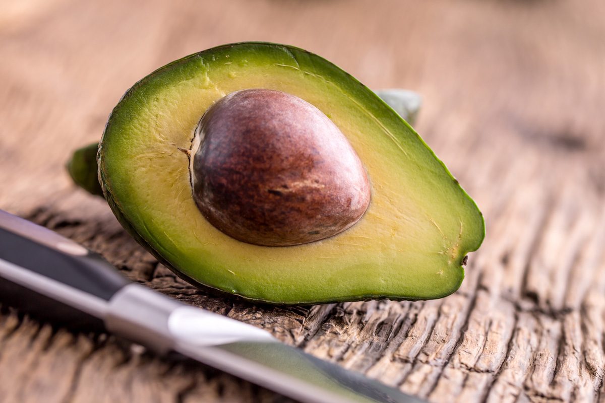 cut avocado on oak wood table